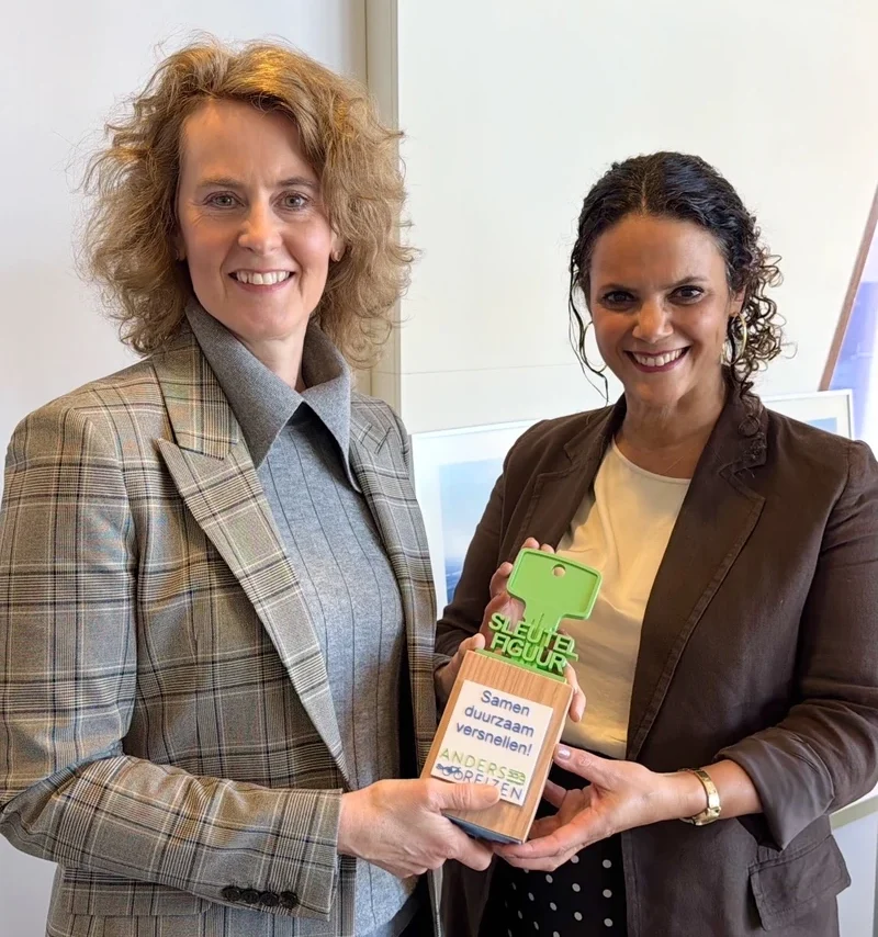 Op de afbeelding overhandigt Gwen Jansen (rechts), directeur van Coalitie Anders Reizen, aan Josefien Kursten (CFO UMC Utrecht) de grote fietssleutel die de leden van Coalitie Anders Reizen ontvangen. De fietssleutel staat symbool voor hun commitment om een sleutelpositie in te nemen in het realiseren van anders reizen als norm in Nederland en binnen hun organisatie.